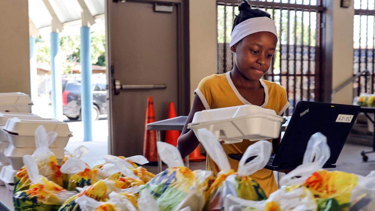 Shaniya Jacqueslouis, recoge el almuerzo en la escuela primaria Toussaint L’Ouverture en el Pequeño Haití, Condado Miami-Dade, en marzo de 2020.
