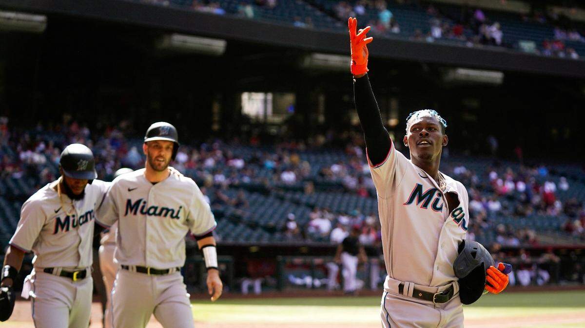 Jazz Chisholm Jr. (der.) celebra tras pegar un jonrón de tres carreras en el noveno inning ante el relevo de los Diamondbacks, en el partido celebrado el 11 de mayo de 2022 en Phoenix, Arizona. Bryan de la Cruz (izq.) y Jacob Stallings (centro) anotaron con el cuadrangular del segunda base de los Marlins.