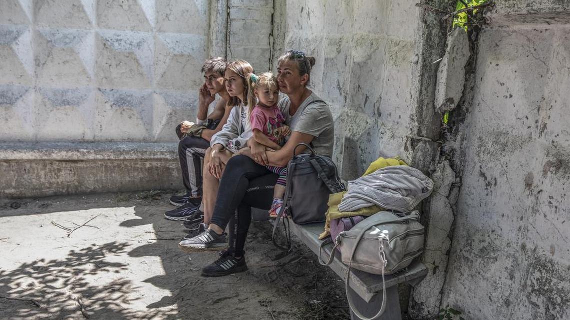 Julia Vasilyseva sits with her son Vladyslav, daughter Milana (on her lap) and friend Anya Navmova as they wait to be evacuated from Lysychansk on June 21.