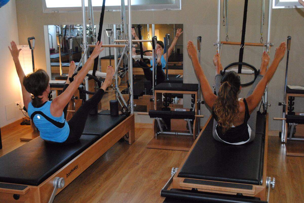Entrenando en una clase de Pilates Máquina con un Reformer.