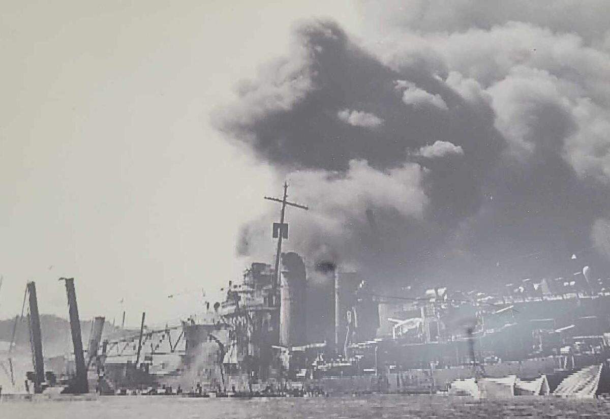 Foto del ataque a Pearl Harbor enmarcada junto a la bandera que se exhibe en el histórico juzgado del condado de Henderson. La bandera ondeó el 7 de diciembre de 1941 en Pearl Harbor durante el ataque japonés.