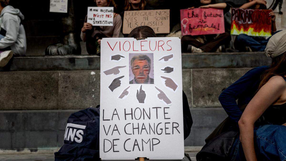 Manifestante sosteniendo un cartel con una foto de Dominique Pelicot y la leyenda “violadores, la vergüenza va a cambiar de bando”. Foto tomada el 14 de septiembre de 2024 en París (Francia) durante la manifestación en apoyo de Gisele Pelicot y las víctimas de violencia sexual.