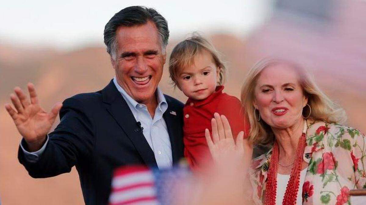 El ex candidato presidencial republicano Mitt Romney sostiene a su nieto Dane Romney, de 2 años, mientras él y su esposa, Ann, saludan a los partidarios en la sede de su campaña durante una fiesta nocturna el martes 26 de junio de 2018 en Orem, Utah.