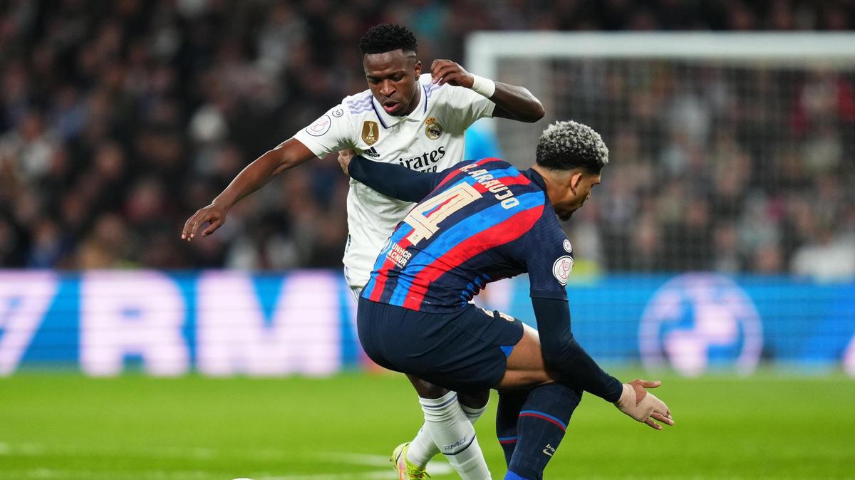El jugador del Real Madrid Vinicius Jr. lucha por el balón con Ronald Araujo, del Barcelona, en el partido de ida de la semifinal de la Copa del Rey, celebrado el 2 de marzo de 2023 en Madrid.