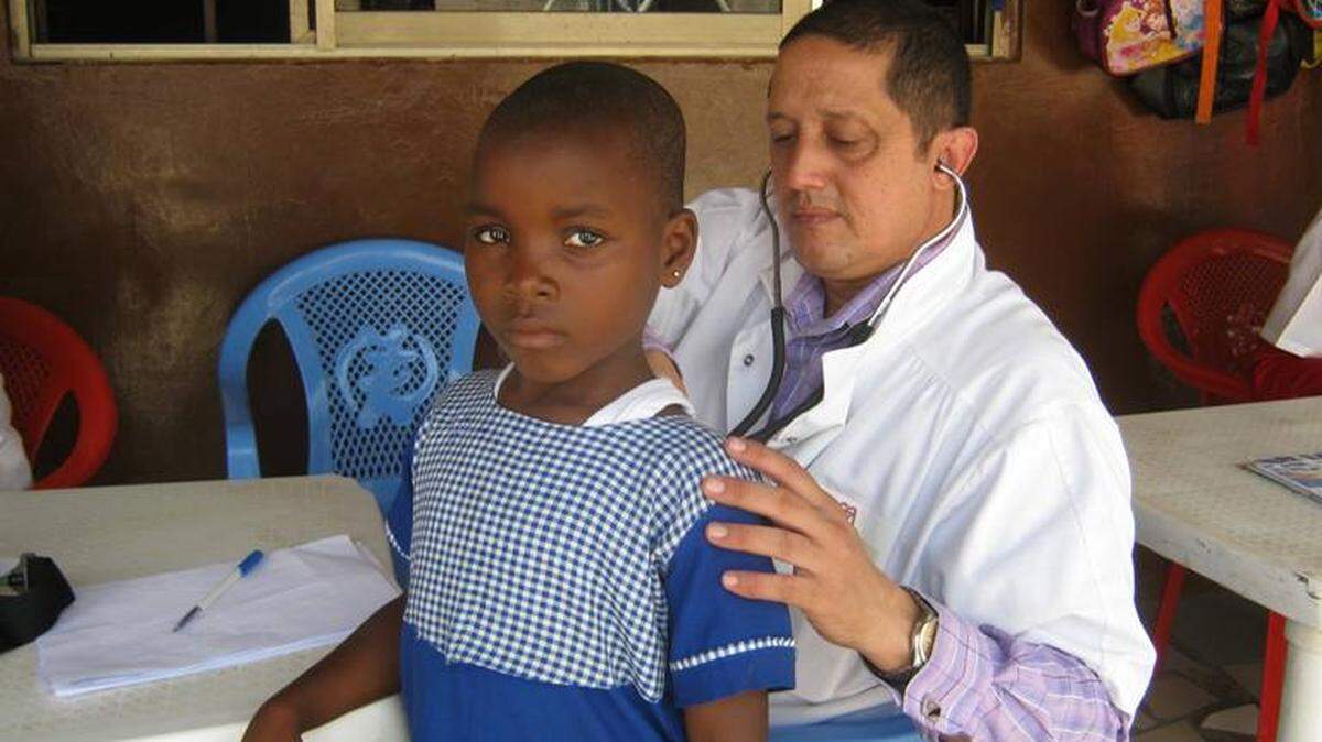 Médico cubano ausculta a niña africana.
