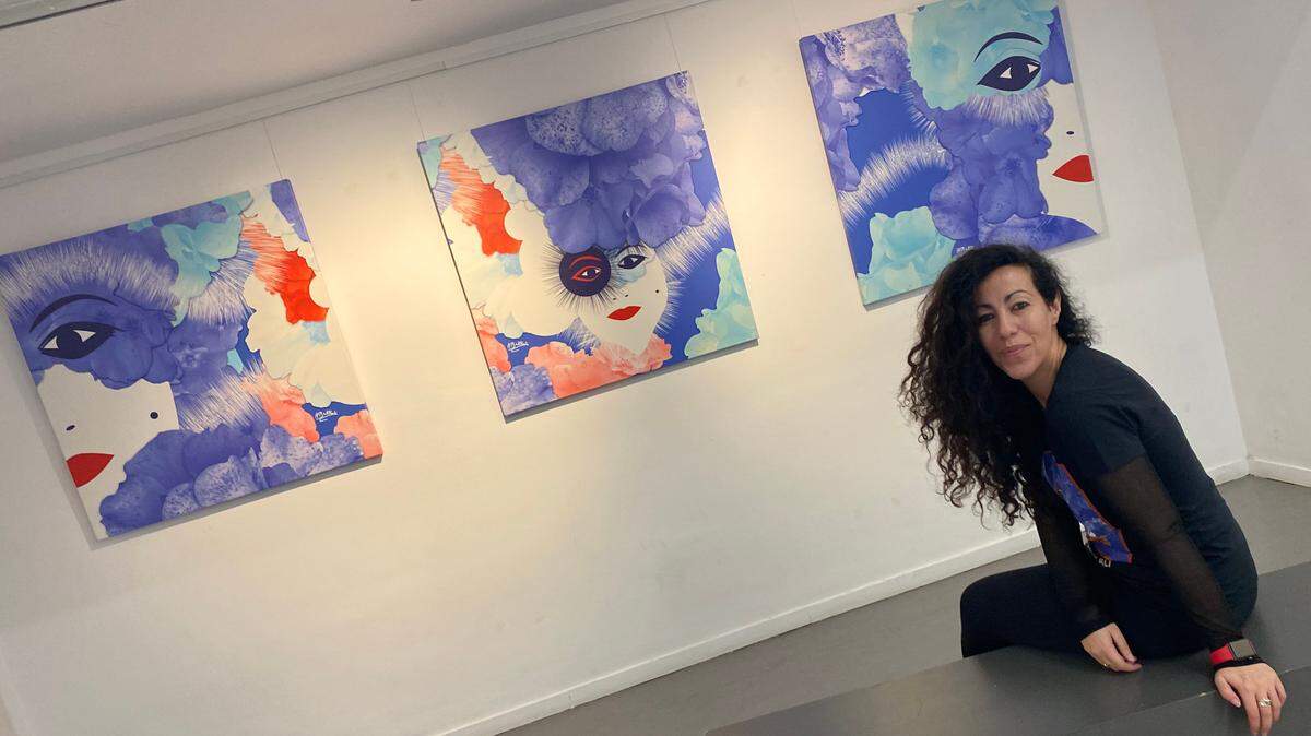 La artista digital, hispano-marroquí, Houda Bakkali ante tres de sus obras, realidad aumentadas.