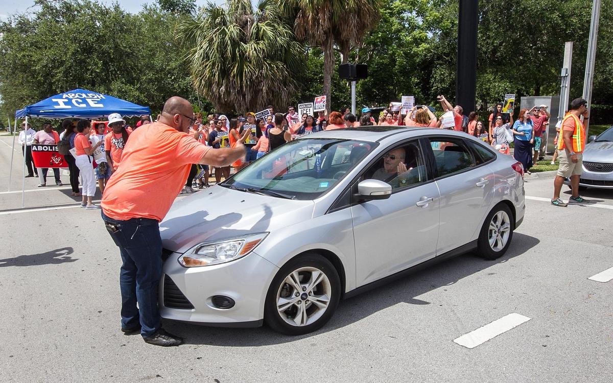 Protesters block the intersection at Southwest 145th Avenue and 29th Street in Miramar outside the ICE building.