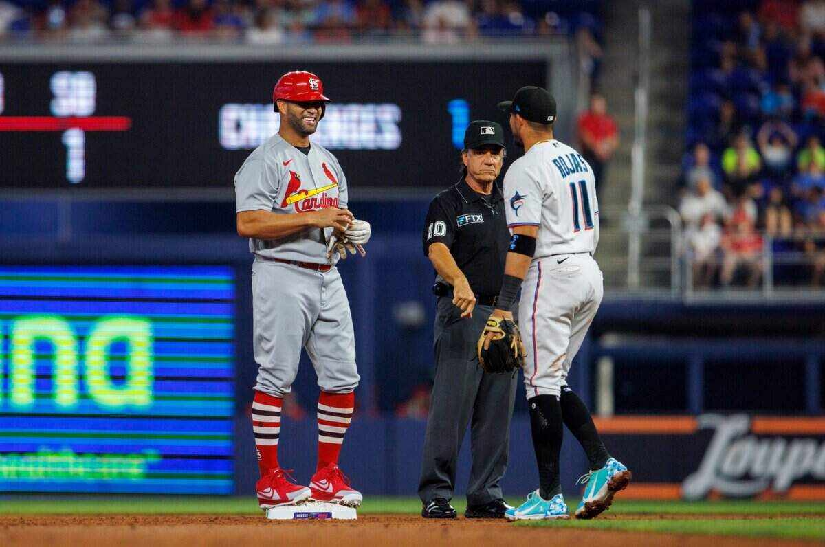 El bateador designado de los Cardenales Albert Pujols habla con el torpedero de los Marlins Miguel Rojas luego de conectar un doble en el segundo inning del partido, celebrado el 19 de abril de 2022 en Miami.