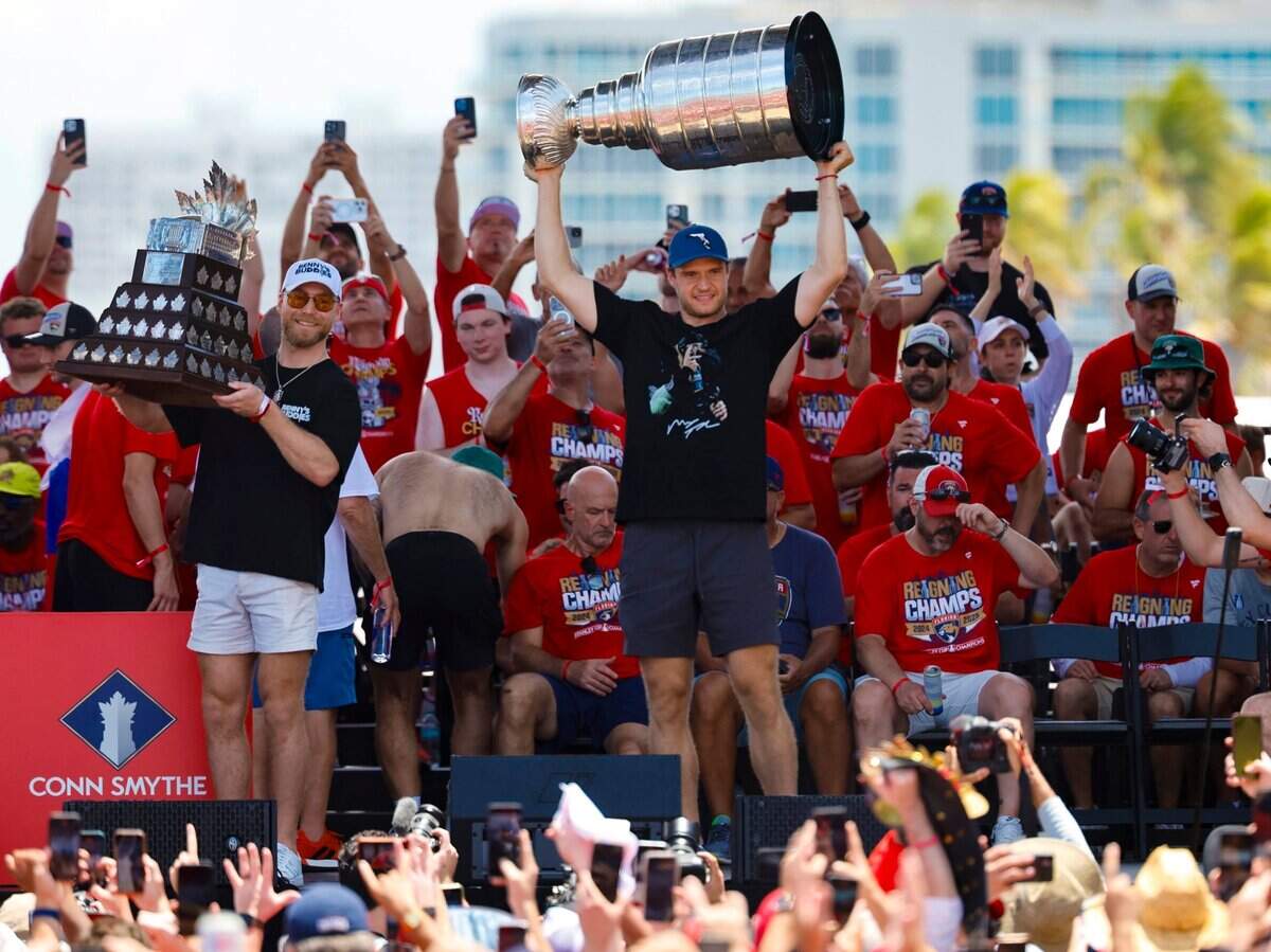El jugador de los Panthers, Sam Bennett (izq.), levanta el trofeo Conn Smythe mientras que el capitán Aleksander Barkov alza la Copa Stanley, durante el desfile de celebración por el segundo título consecutivo de la NHL conseguido por el equipo, el domingo 22 de junio de 2025 en Fort Lauderdale, Florida.