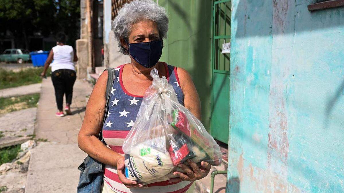 Una cubana lleva alimentos, en el municipio de Arroyo Naranjo en La Habana, el 11 de agosto de 2021.  YAMIL LAGE / AFP/ Getty Images