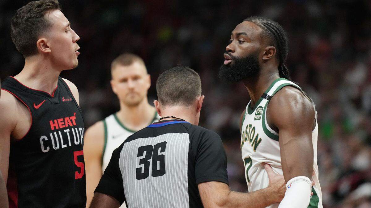 Los basquetbolistas del Heat Duncan Robinson (izq.) y los Celtics Jaylen Brown intercambian palabras cerca de la línea de faltas, tras una polémica jugada en el partido del domingo en Miami.