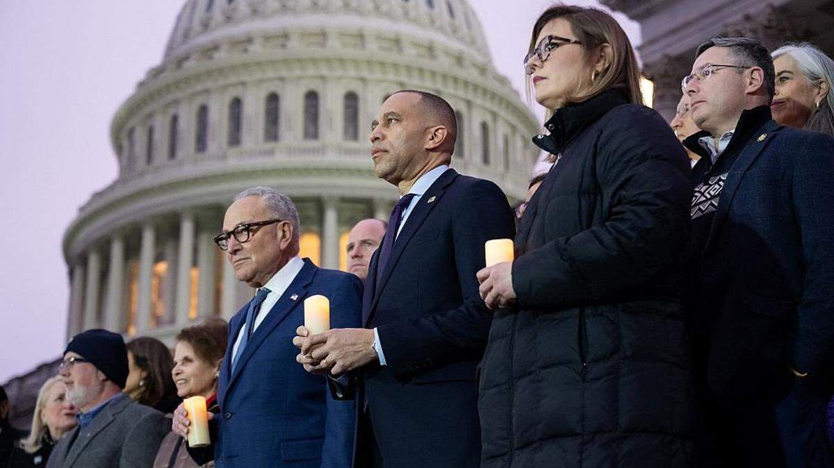US House Minority Leader Hakeem Jeffries, Democrat of New York, and US Senate Minority Leader Chuck Schumer, Democrat of New York, lead Democratic members of Congress and family members of fallen US Capitol Police officers in a moment of silence marking the fifth anniversary of the January 6, 2021 attacks on the US Capitol, outside the US Capitol in Washington, DC, on January 6, 2026. (Photo by SAUL LOEB / AFP via Getty Images)