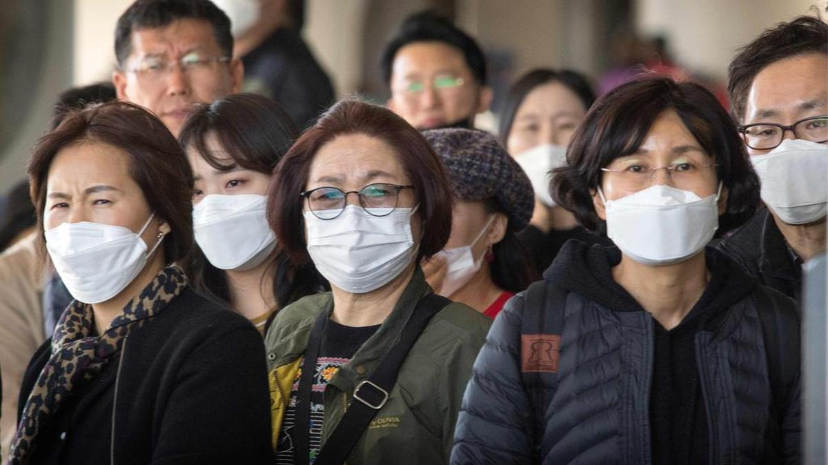 Pasajeros usan máscaras faciales para protegerse contra la propagación del Coronavirus cuando llegan en un vuelo desde Asia al Aeropuerto Internacional de Los Ángeles, California, el 29 de enero de 2020.