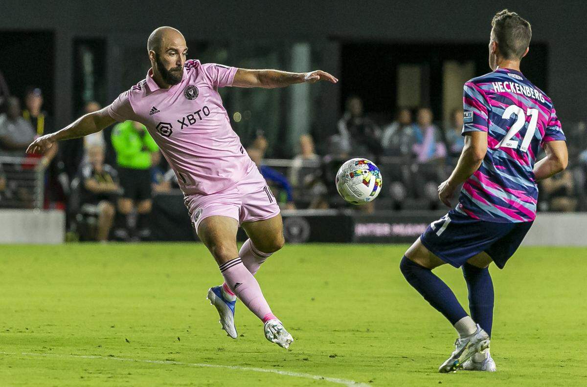 El delantero del Inter Miami Gonzalo Higuaín (izq.) patea la pelota ante la marca de Christopher Heckenberg, del Tormenta FC, en la Copa de Estados Unidos, celebrado el 10 de mayo de 2022 en en el DRV PNK Stadium en Fort Lauderdale, Florida.