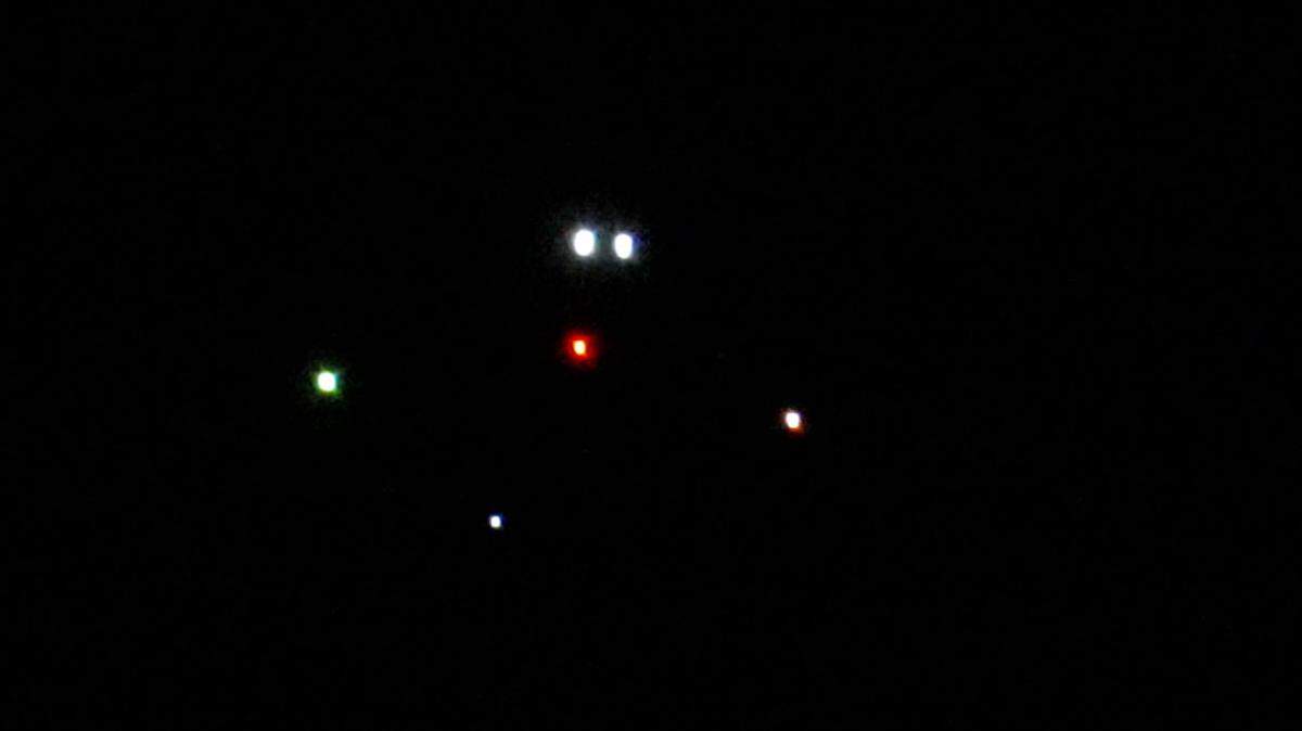 An aircraft kills headlights as it flies by Trump National Golf Course approaching Naval Weapons Station Earle