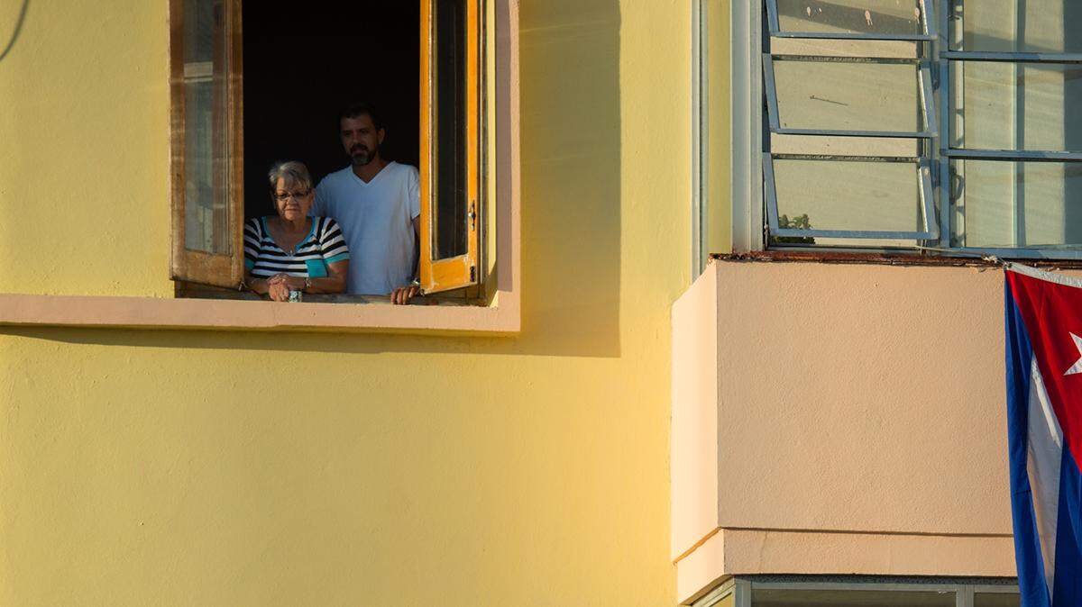 ARCHIVO - Banderas de Cuba y EEUU cuelgan de una venta de un apartamento en La Habana, Cuba. 