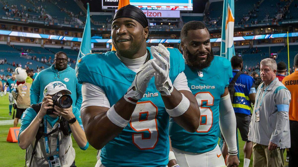 Miami Dolphins tight end Jonnu Smith (9) and linebacker Anthony Walker Jr. (6) greet fans while walking off the field after the Dolphins’ 29-17 victory over the San Francisco 49ers during an NFL game at Hard Rock Stadium on Sunday, Dec. 22, 2024, in Miami Gardens, Florida.