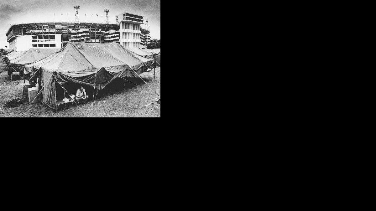 En esta foto de archivo de 1980, un refugiado cubano se refugia en una carpa montada sobre la base del Orange Bowl para dar cabida a la gran afluencia de refugiados a Miami durante el éxodo marítimo del Mariel en la primavera y el verano de 1980.