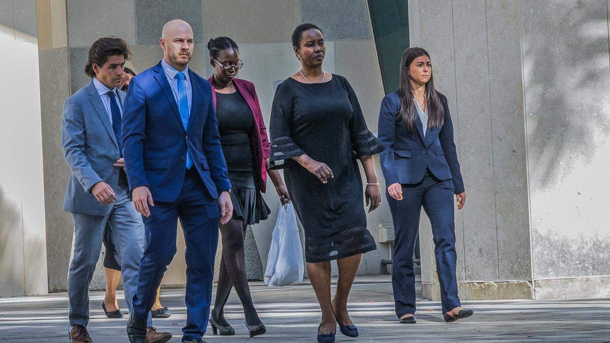 Funcionarios del Departamento de Justicia de EEUU y personal de seguridad acompañan a Martine Moïse (segunda de la derecha), viuda del presidente haitiano Jovenel Moïse, y a su hija Jormalie Moïse (centro), a su salida del Tribunal Federal Wilkie D. Ferguson Jr.