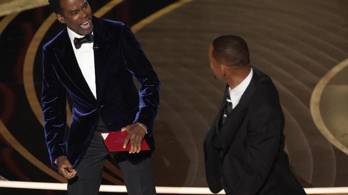 El presentador Chris Rock, a la izquierda, reacciona tras ser confrontado por Will Smith mientras presentaba el premio al mejor documental en la ceremonia de los Oscar, tras hacer un chiste sobre su esposa, Jada Pinkett Smith, el domingo 27 de marzo de 2022 en el Teatro Dolby en Los Ãngeles. (Foto AP/Chris Pizzello)