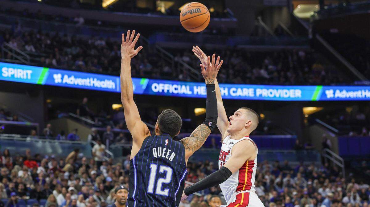El jugador del Heat Tyler Herro (der.) tira al aro ante la marca de Trevelin Queen, del Magic, en el partido celebrado el 26 de diciembre de 2024 en Orlando.
