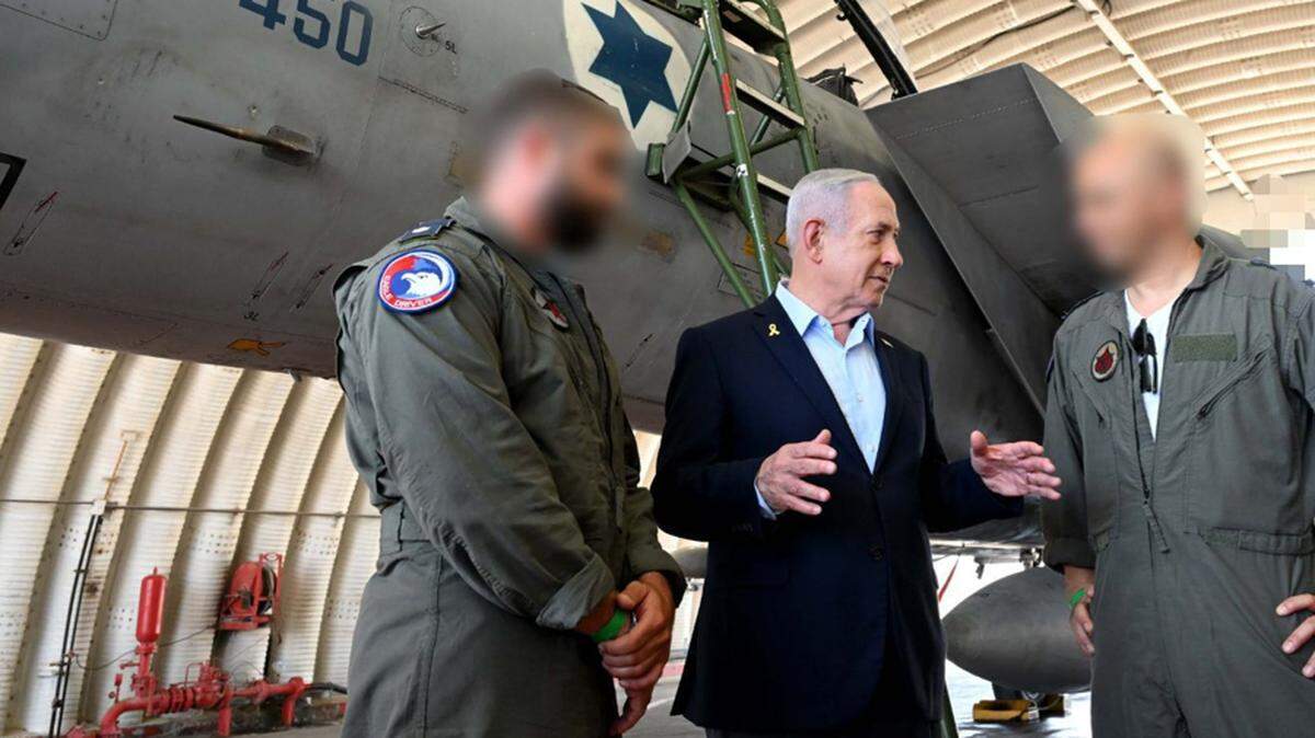 El primer ministro israelí, Benjamín Netanyahu (c), durante su visita a la base aérea de Tel Nof, en el centro del país, el 16 de junio de 2025. 