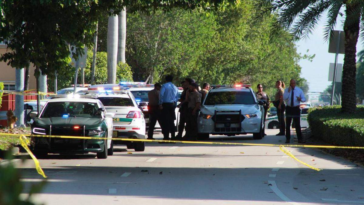 Agentes y detectives del Condado Miami-Dade investigan en el sitio donde hallaron tres personas muertas dentro de un automóvil estacionado el viernes 7 de junio de 2024.