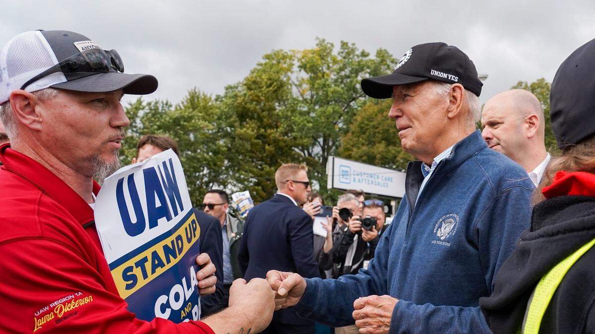 El presidente Joe Biden choca el puño y luego le da la mano a uno de los trabajadores que hace huelga en la General Motors Willow Run Redistribution en Belleville, Michigan, el martes 26 de septiembre de 2023.