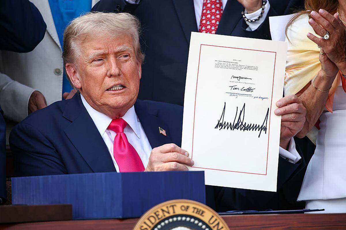 El presidente de Estados Unidos, Donald Trump, acompañado por legisladores republicanos, promulga el One Big Beautiful Bill (la Ley Única, Grande y Hermosa) durante un picnic familiar militar con motivo del Día de la Independencia en el jardín sur de la Casa Blanca, el 4 de julio de 2025, en Washington, D.C.