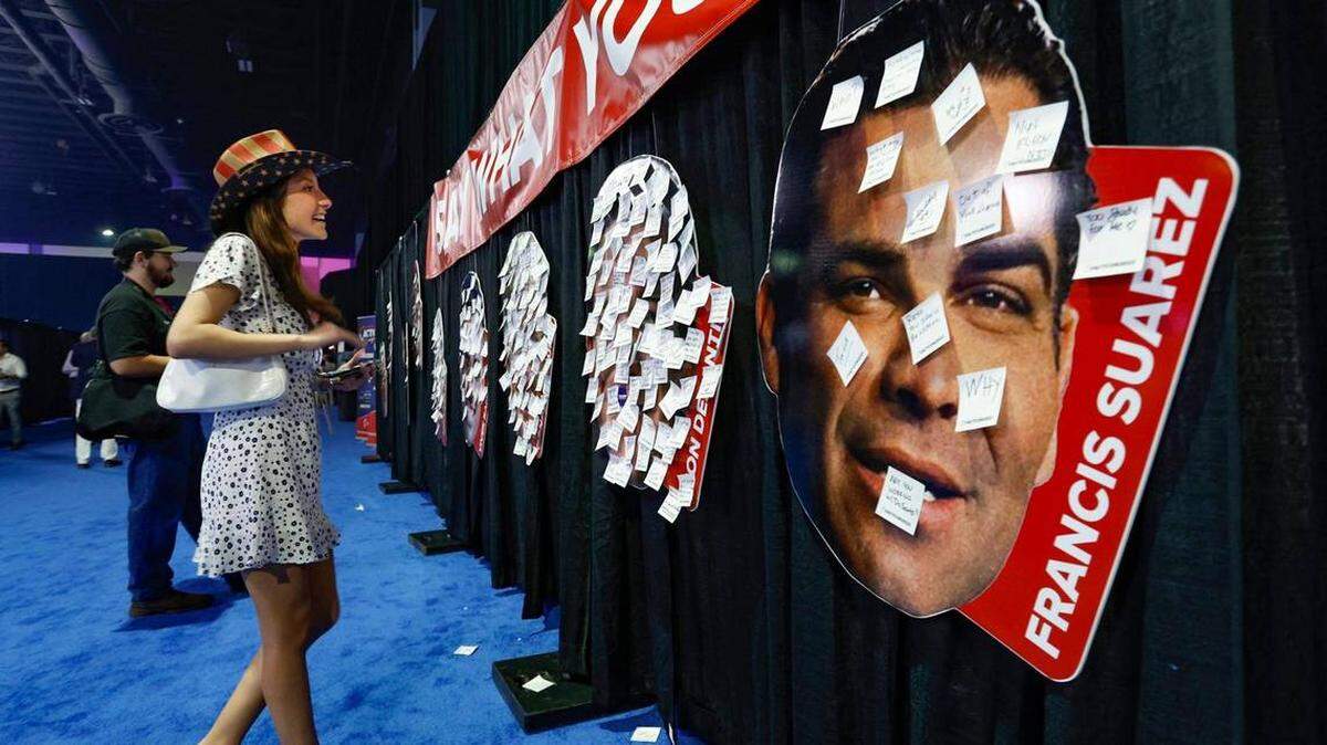 Isabella Bertolozzi, de 21 años, observa los comentarios que se colgaron en fotos de los candidatos presidenciales, entre ellos el alcalde de Miami, Francis Suárez en el Centro de convenciones de Palm Beach.