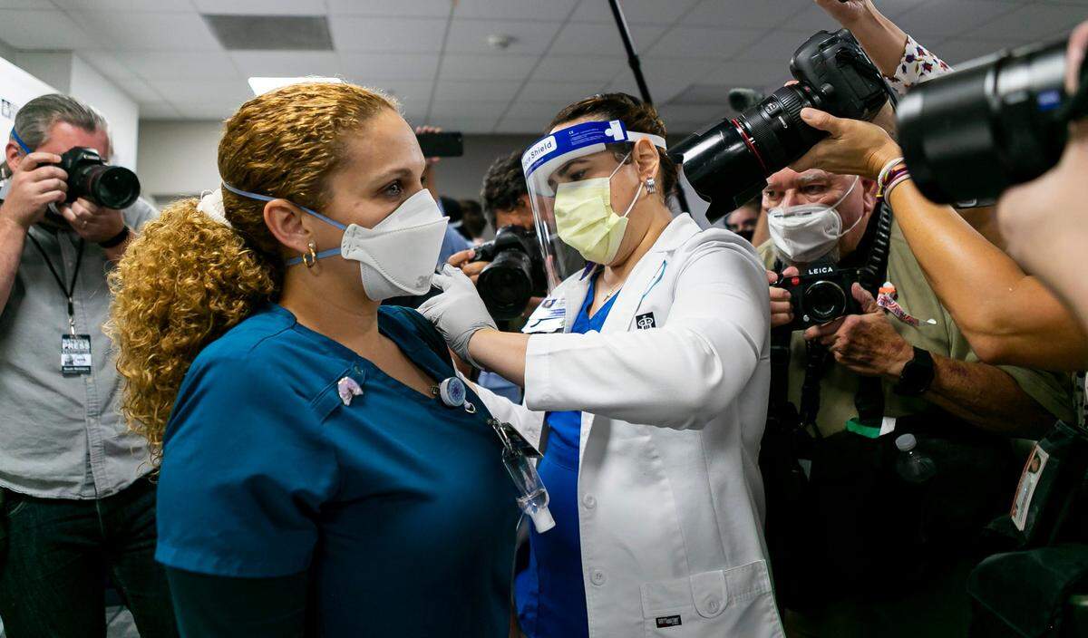 La terapeuta Elizabeth Plasencia recibe la vacuna Pfizer BioNTech COVID-19 en el Jackson Memorial Hospital en Miami, Florida, el martes 15 de diciembre de 2020.