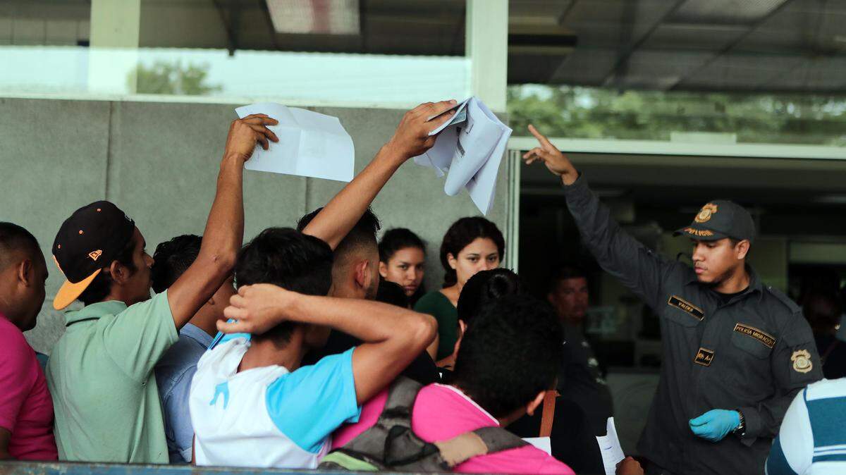 An immigration official asks for documents from Nicaraguans trying to cross into Costa Rica.