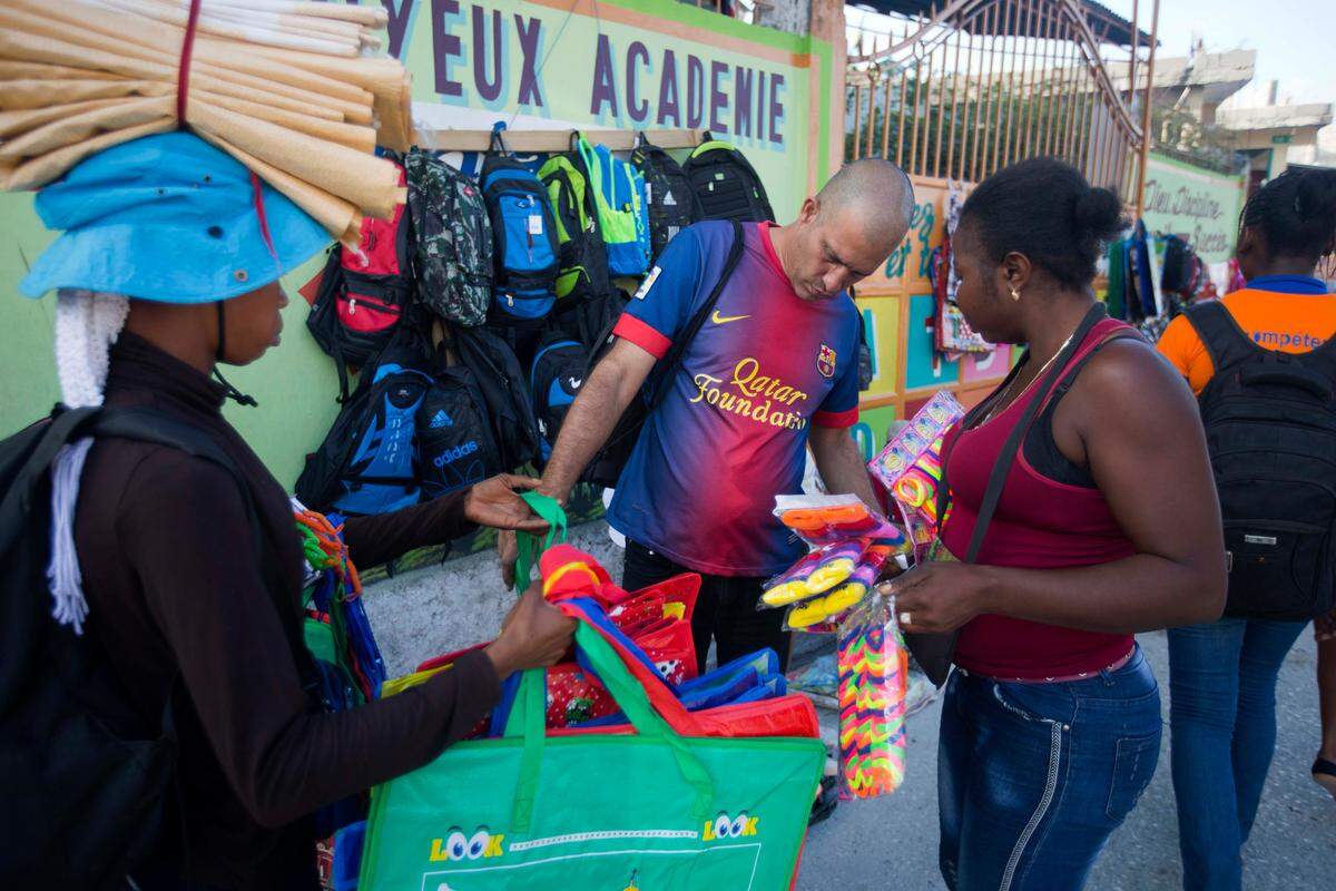 Un cubano mira unas carteras que se venden en un mercado de Port-au-Prince, Haití, el 10 de diciembre del 2018. (AP Photo/Dieu Nalio Chery)