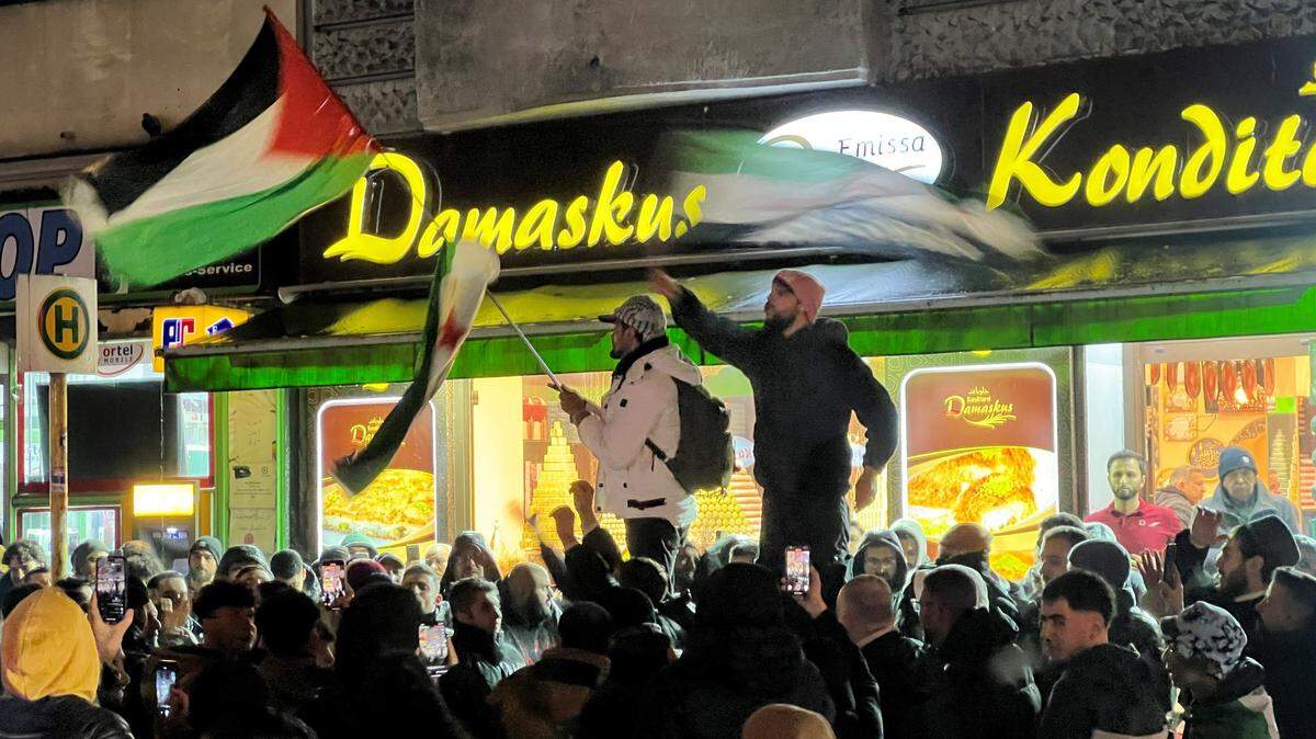 Un grupo de personas se reúnen frente a una panadería de Damasco para celebrar el avance de los rebeldes sobre la capital de Siria, el 7 de diciembre de 2024.
