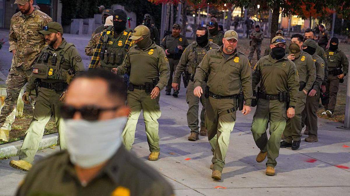CHARLOTTE, NORTH CAROLINA - NOVEMBER 20: Federal Agents walk through a park in Downtown Charlotte after taking a group photograph in Charlotte, North Carolina. Agents are conducting "Operation Charlotte's Web," an ongoing immigration enforcement surge across the Charlotte region. (Photo by Ryan Murphy/Getty Images)