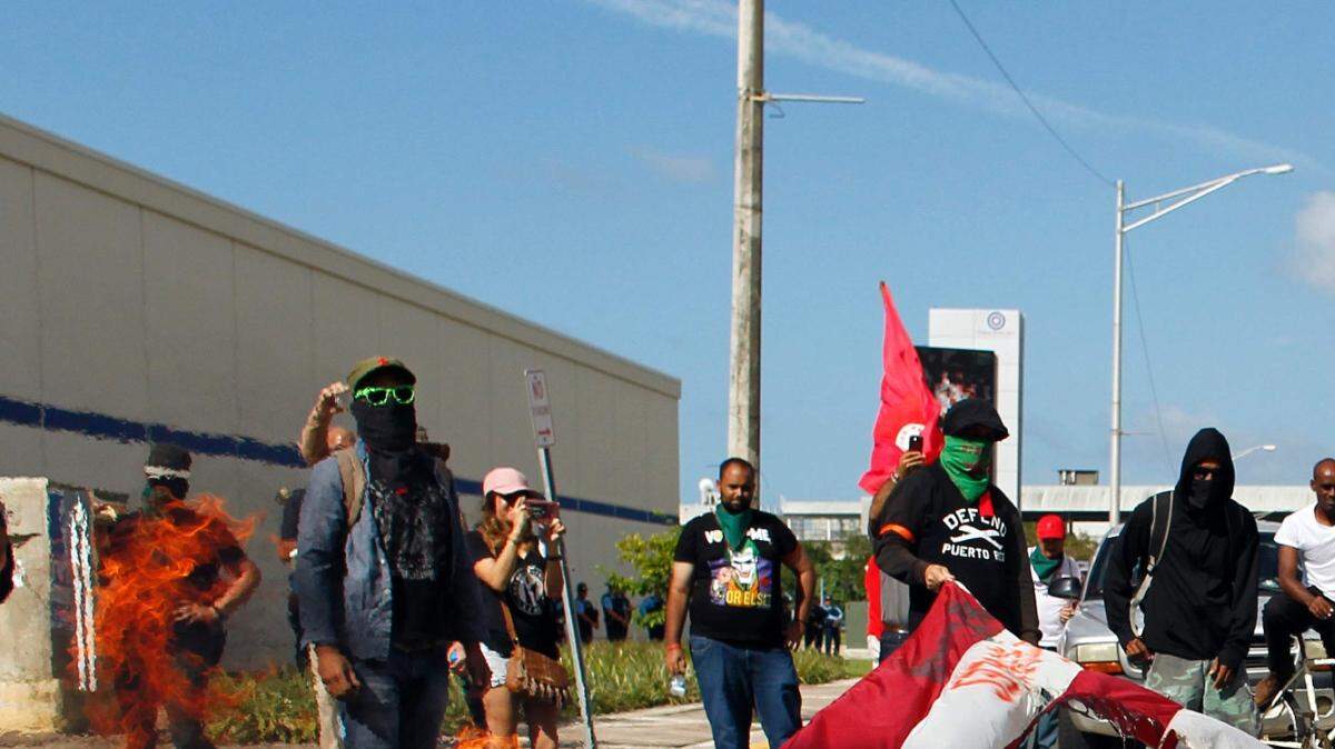 Manifestantes queman una bandera de Estados Unidos durante una protesta contra el referéndum para el estatus político de Puerto Rico en San Juan, el 11 de junio de 2017.