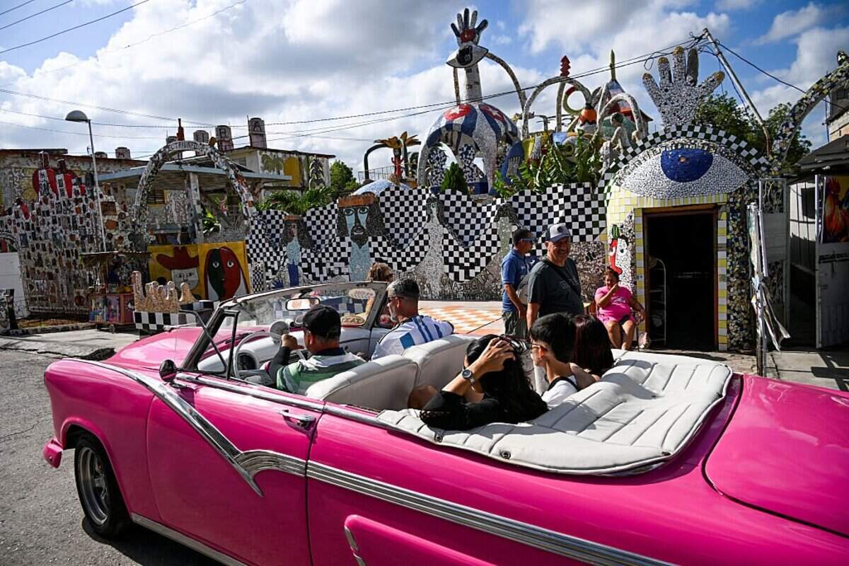 Turistas pasean en un coche clásico estadounidense durante un recorrido para admirar las obras del artista cubano José Fuster en el pueblo costero de Jaimanitas, en las afueras de La Habana, el 30 de abril de 2025. En 1994, el artista cubano José Fuster decoró la entrada de su casa en Jaimanitas con mosaicos. Treinta años después, la comunidad se ha transformado en una gigantesca y exuberante obra de arte.