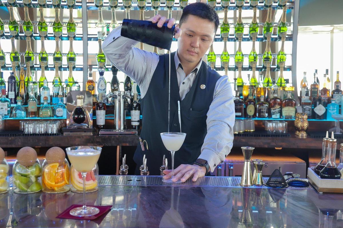 El barman Daniel Kan crea el cóctel Tango on Top en Pier Top con Amaro Nonino y Strega, dos licores de hierbas italianos; prosecco; jugo de piña y té matcha de coco.