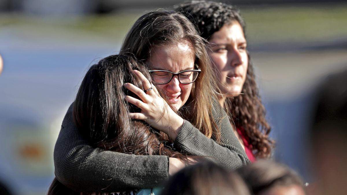 Students embrace outside Marjory Stoneman Douglas High School in Parkland, Florida, after being released from a lockdown on Feb. 14, 2018, after a gunman’s rampage. Seventeen students and staff at the school were killed.
