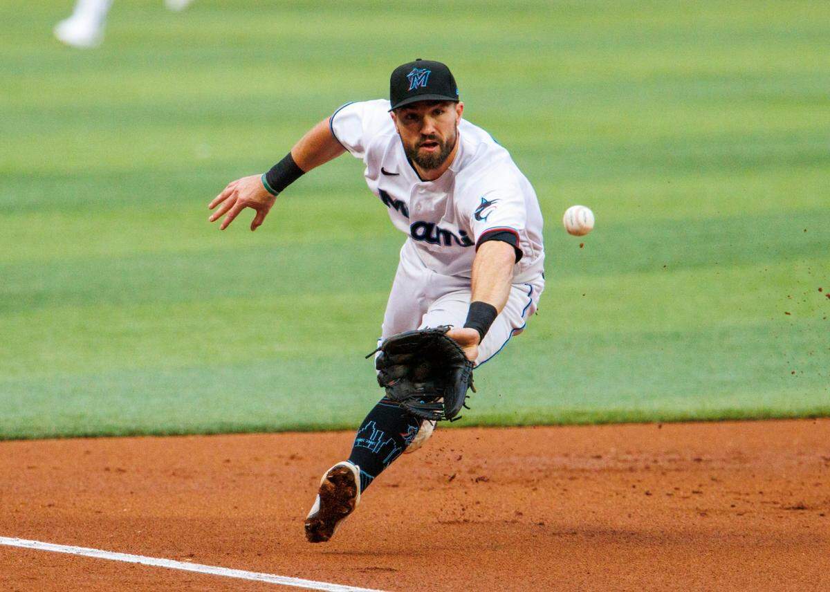 El tercera base de los Marlins Jon Berti fildea un roletazo del receptor de los Rockies de Colorado, Elías Díaz, en el segundo inning del partido celebrado el 22 de junio de 2022 en Miami.