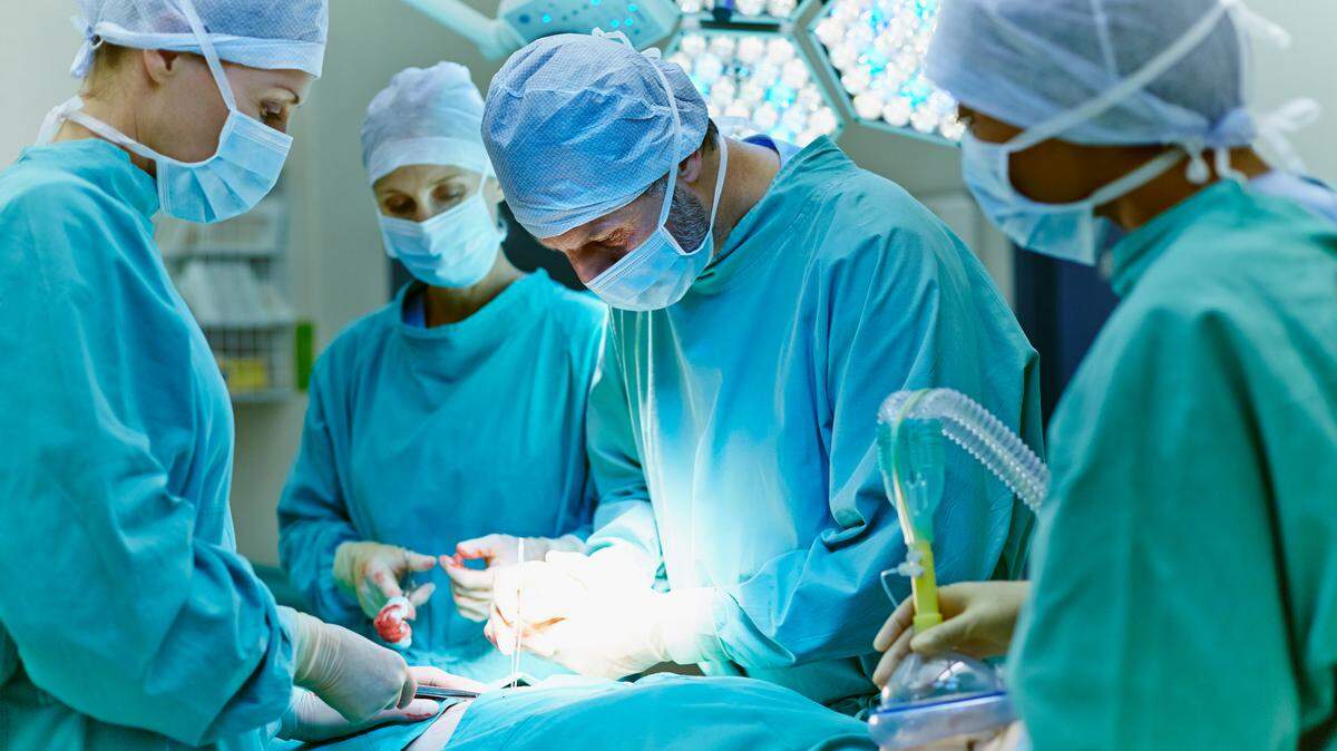 Group of surgeons performing surgery on patient in operating room