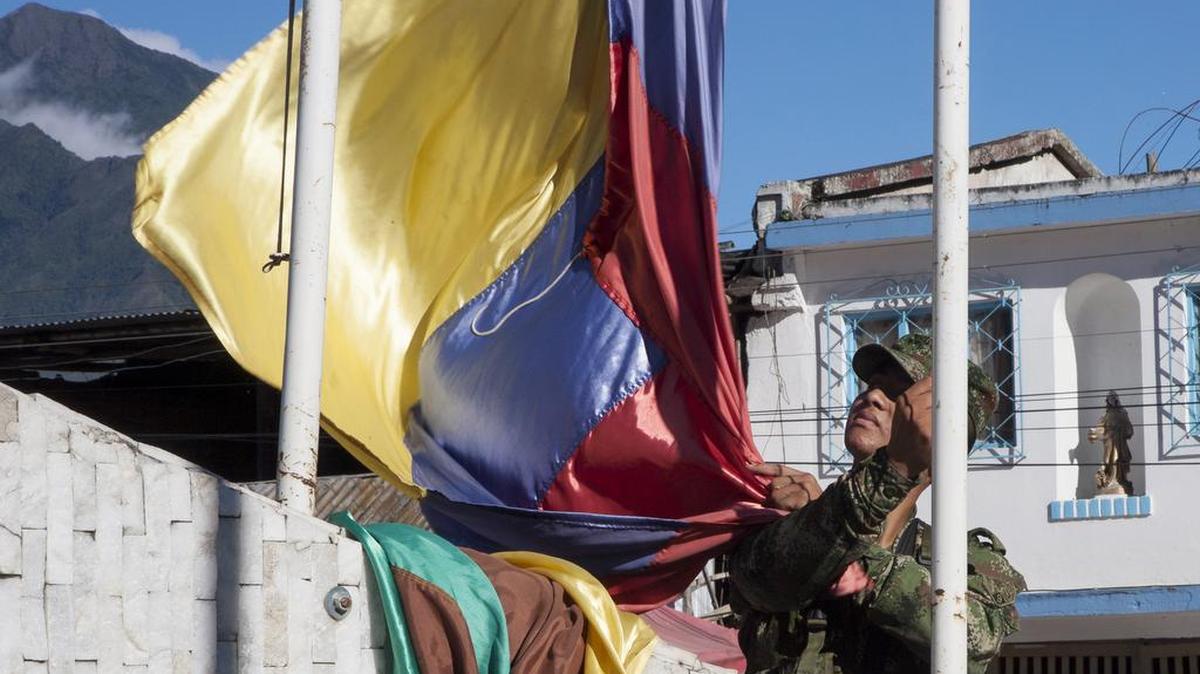 Fotografía del 4 de junio de 2019 que muestra un soldado que iza la bandera de Colombia en el municipio de Policarpa, Nariño (Colombia).