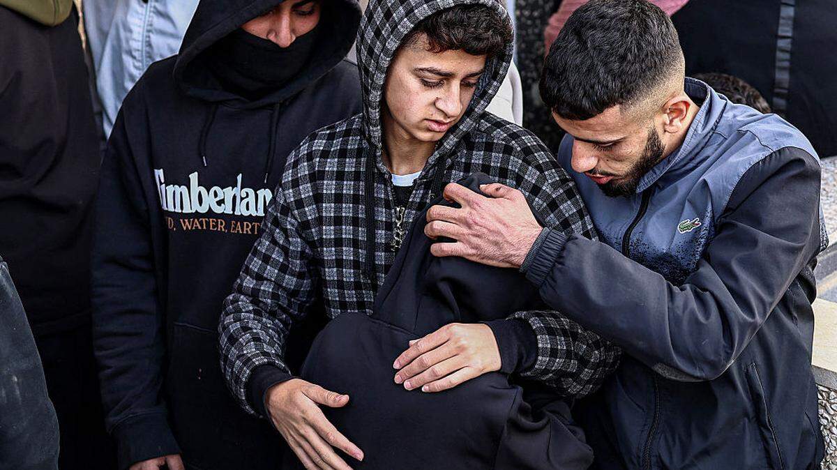 Un doliente recibe consuelo mientras reacciona durante el funeral de Amir Mutasem Odeh, un palestino de 28 años que, según los informes, murió en un ataque de colonos israelíes el día anterior, en la aldea de Qusra, al sur de Nablus, en la Cisjordania ocupada, el domingo 15 de marzo de 2026.