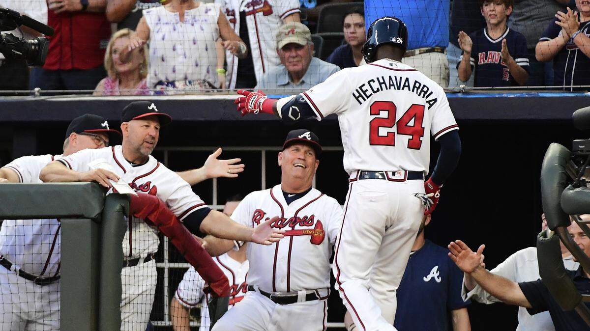 El torpedero de los Bravos Adeiny Hechavarría celebra al llegar al banco del equipo luego de pegar un jonrón de dos carreras en el segundo inning del partido ante los Marlins, efectuado el 21 de agosto de 2019 en Atlanta