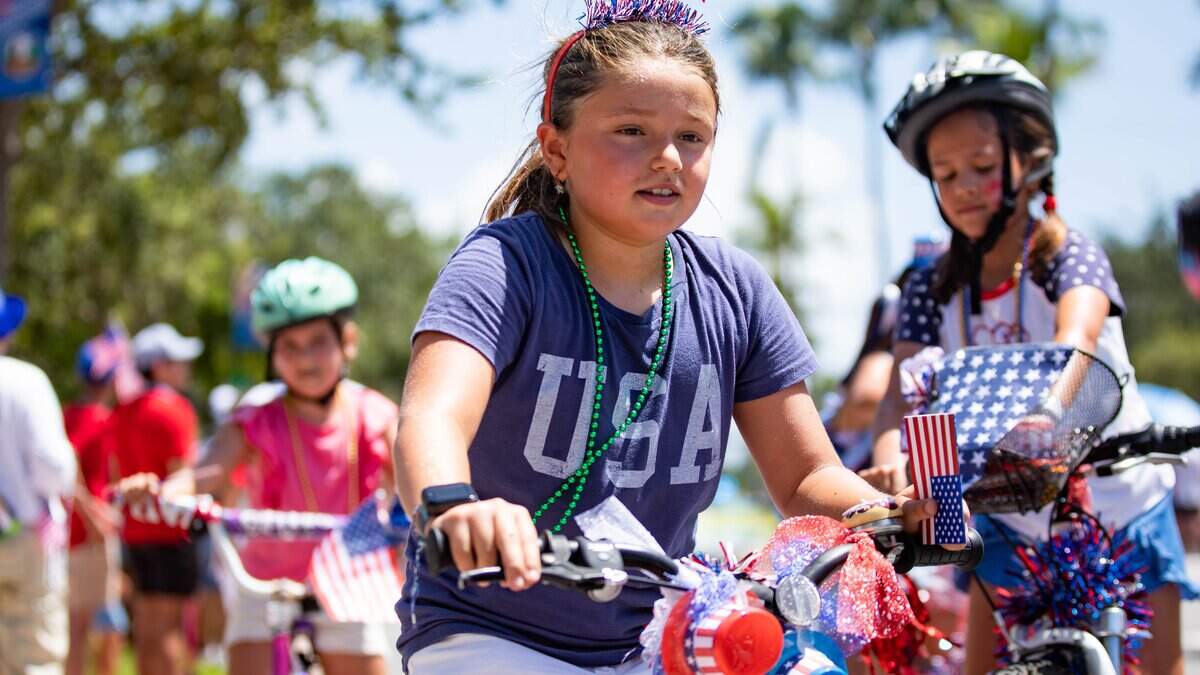Una niña monta en bicicleta por la calle durante un desfile del Día de la Independencia el jueves 4 de julio de 2024 en Key Biscayne, Florida. El desfile del 4 de julio de Key Biscayne es uno de los más antiguos del sur de Florida; comenzó en 1959.