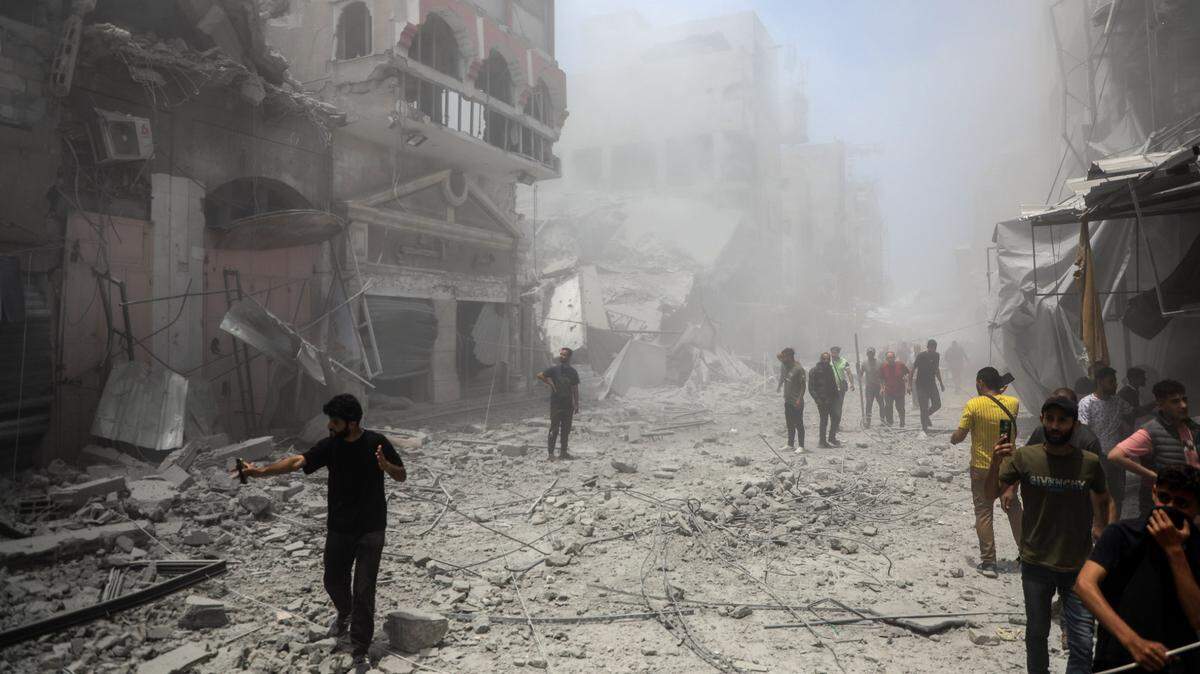 Varios palestinos caminan entre los escombros de las casas destruidas después de un ataque aéreo israelí en la Ciudad de Gaza, el sábado, 31 de mayo de 2025.