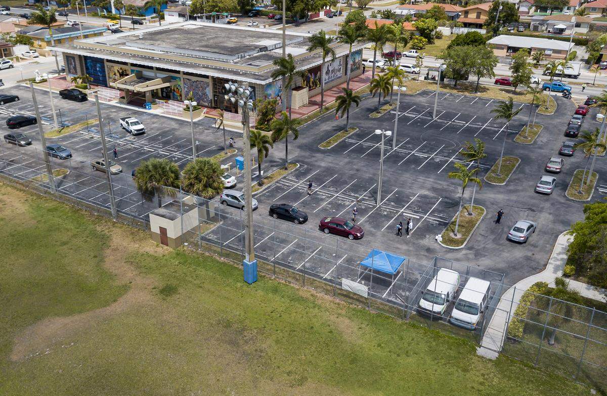 Miami-Dade County residents lineup in their cars to receive a printed unemployment form at John F. Kennedy Library in Hialeah, Florida on Tuesday, April 7, 2020.