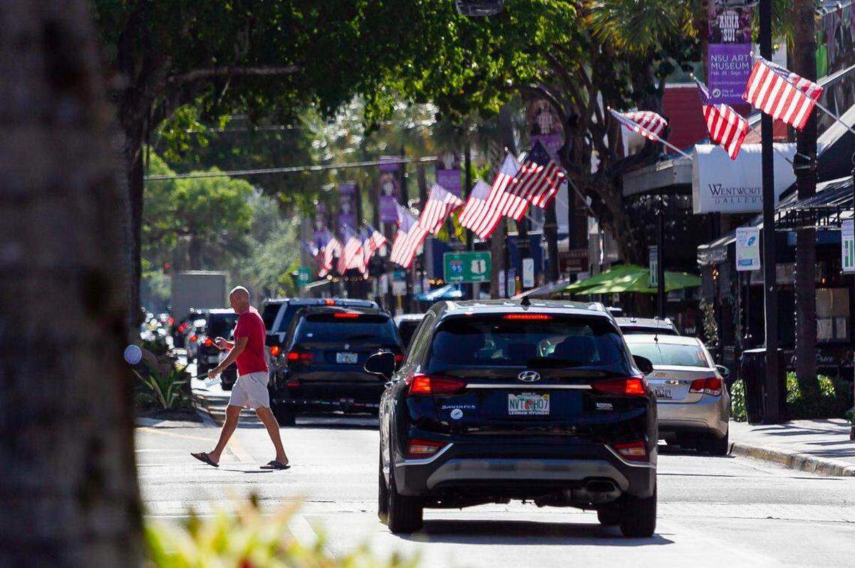 Personas caminan por East Las Olas Boulevard en Fort Lauderdale, Florida, el lunes 26 de abril de 2021.