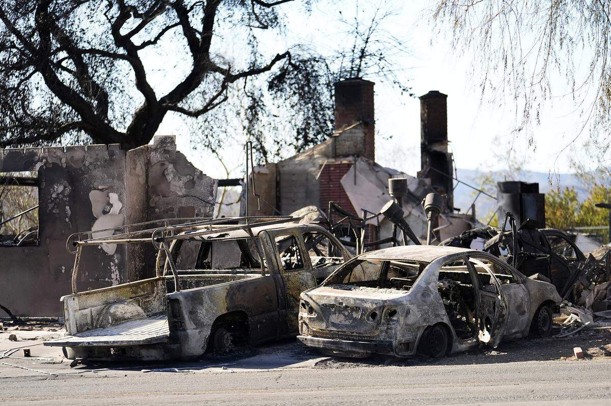 Restos de dos autos y una casa destruidos por un incendio que comenzó el viernes son vistos en el vecindario de Altadena, en Los Ángeles, el domingo 12 de enero de 2025.