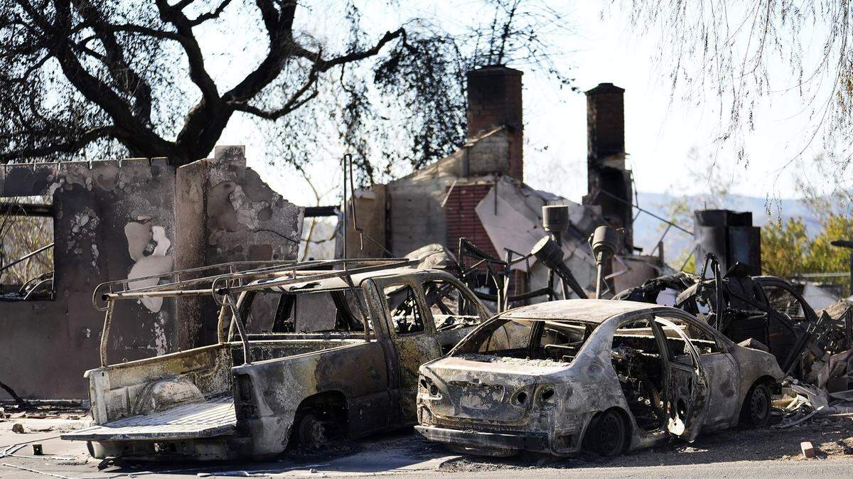 Restos de dos autos y una casa destruidos por un incendio que comenzó el viernes son vistos en el vecindario de Altadena, en Los Ángeles, el domingo 12 de enero de 2025.